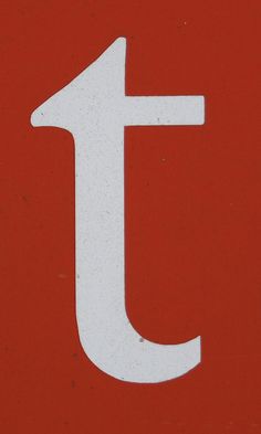 a close up of a street sign with the letter t on it