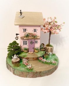 a pink doll house sitting on top of a tree stump