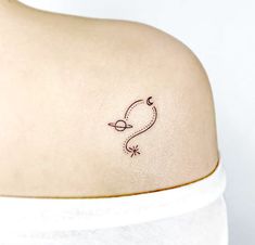 a small tattoo on the back of a woman's shoulder