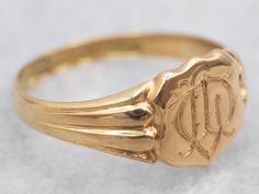 "This intricate signet ring is crafted from yellow gold, featuring a classic shield shape and beautiful etched design. Luxurious and elegant, this ring offers a timeless look that's perfect for everyday wear. Metal: 18K Yellow Gold Top Measurements: 8.2 x 9.6 mm, Shield Shape Ring Size: 7.50 Marks: \"[JS&S18\" Stamped on the inside band SKU #: A29671 Each piece has been identified and graded by a Graduate Gemologist who has been certified by the Gemological Institute of America (GIA). We have six brick-and-mortar storefronts in Maine, Massachusetts, and New Hampshire and have been in business for over 25 years! Please visit our Shop's About Page or our website for more information about our jewelry. For questions about diamond grading, we recommend the  Gemological Institute of America (GI Signet Ring Gold, Gold Shield, Hair Jewellery, Top Measurements, Pocket Watch Chain, Gold Signet Ring, Jewelry Style, Gold Gift, Gold Top