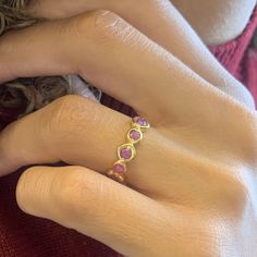 a close up of a person's hand wearing a ring with three stones on it