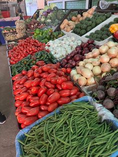 many different types of vegetables on display at an outdoor market