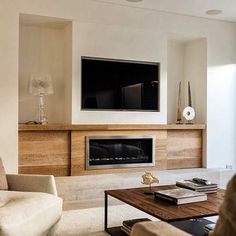 a living room filled with furniture and a flat screen tv mounted on the wall above a fireplace