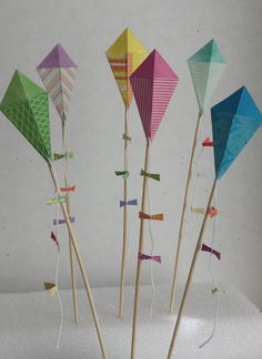 four colorful kites are on sticks in the snow