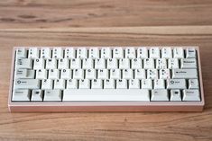 a computer keyboard sitting on top of a wooden table