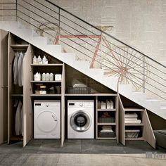 a washer and dryer are under the stairs in this modern laundry room,