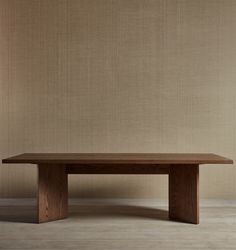 a wooden table sitting on top of a hard wood floor next to a beige wall