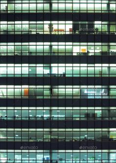 an office building at night with lots of windows lit up in the evening - stock photo - images