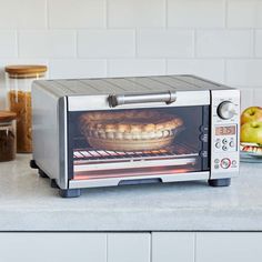 a toaster oven sitting on top of a counter with food in front of it