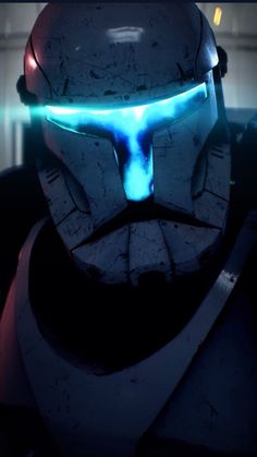 a man in a helmet with glowing blue lights on his face and chest is staring into the distance