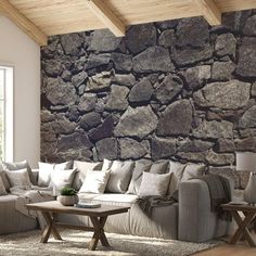 a living room filled with furniture and a stone wall behind the couch is a coffee table