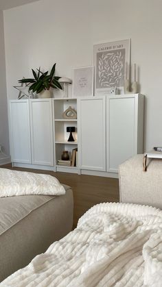 a bedroom with white walls and furniture in it