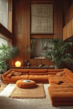 a living room with orange couches and potted plants in the corner, along with white rugs