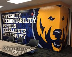 an empty conference room with chairs and a large wall mural in the background that says integrity, acconttability, passion, excellence, incisitivty