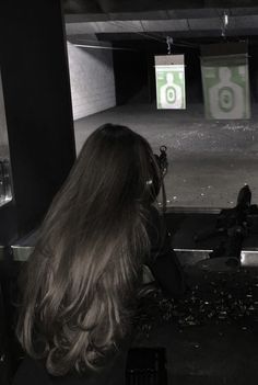 a woman taking a photo in an empty parking garage with her camera on the ground