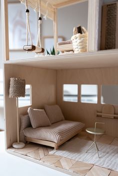 a doll house with a couch, chair and table in the room next to it