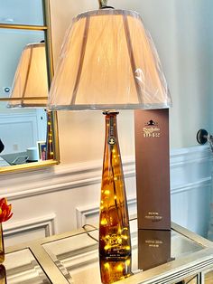 a lamp that is sitting on top of a table next to a box with a wine bottle in it