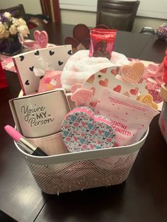 a basket filled with lots of valentine's day items on top of a table