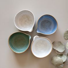 four ceramic bowls sitting next to each other on a table