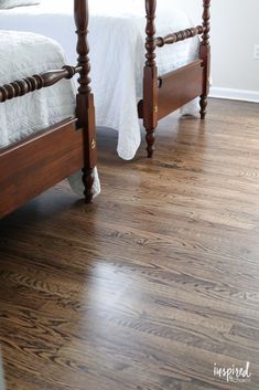 two twin beds in a bedroom with wood floors