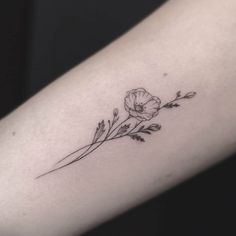 a small flower tattoo on the arm