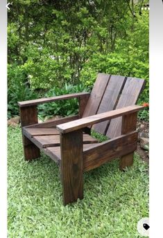 a wooden chair sitting on top of a lush green field