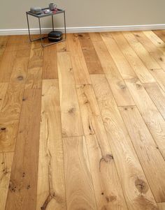 an empty room with wood flooring and a metal stand on the side walk way