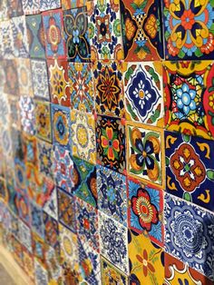 many colorful tiles are arranged on the wall