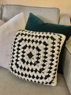 a black and white crocheted pillow sitting on top of a couch