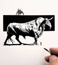 a hand holding a pen and drawing an image of a bull with long tusks