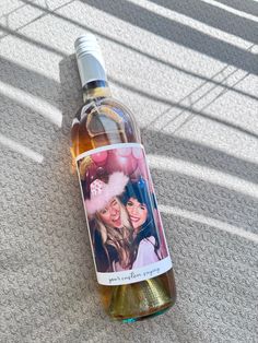 a bottle of wine sitting on top of a carpeted floor next to a wall