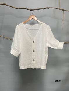 "Classic white and black women V-neck button down blouse, easy to be layered with camisole as a shirt or by itself as a blouse. The puffy sleeves are very flattering; pair it with pants, jeans or skirts for a chic and young look. - Prewashed linen - Relaxed fit - Button down opening - Elbow-length puffed sleeves with cuff and button - Can be tucked or untucked Please provide your shoulder width, full bust measurement ( measured around the fullest part) and your height in the note to seller box. White V-neck Blouse With Buttons, Linen Short Sleeve Blouse For Day Out, Short Sleeve Linen Blouse For Day Out, Summer Solid Color Puff Sleeve Blouse, Summer V-neck Tops With Buttons, V-neck Tops With Buttons, V-neck Linen Blouse For Work, Elegant White Short Sleeve V-neck Top, Summer Linen Blouse With Puff Sleeves