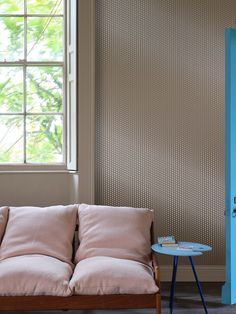 a couch and table in a room with a blue door on the wall behind it