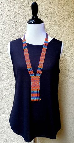 Colorful long seed bead African necklace with fun fringe in a striking pattern. This necklace says summer, beach, resort.  Necklace measures 16 inches, pendant measures 4 1/2 inches from top to the bottom of the fringe.  No clasp, just slip over your head.   Striking with a swingy beach dress or a jean jacket.     Shop more necklaces here: https://www.etsy.com/shop/BoutiqueByMaryam?section_id=21694658  Be sure to visit the rest of my shop here: https://www.etsy.com/shop/boutiquebymaryam Adjustable Multicolor Beaded Lariat Necklace, Southwestern Multicolor Beaded Necklaces For Beach, Southwestern Style Multicolor Beaded Necklaces For Beach, Southwestern Style Multicolor Beaded Necklace For Beach, Colorful Beads Lariat Necklace For Beach, Adjustable Fringe Necklace For Beach, Multicolor Beaded Tassel Necklace For Festivals, Bohemian Beach Tassel Necklace With Fringe, Southwestern Style Multicolor Necklace For Beach