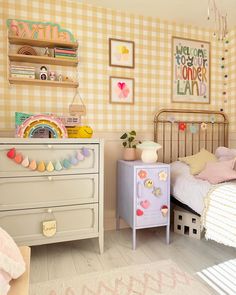 a child's bedroom decorated in pastel colors and gingham wallpaper