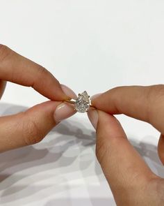 two hands holding a diamond ring on top of each other