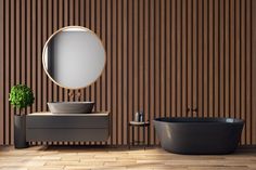 a bathroom with a tub, sink and round mirror on the wall next to it