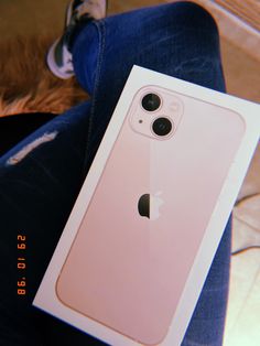 an apple phone is sitting on someone's lap with the box open to show it