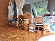 the inside of a van with various items in it and hanging from hooks on the wall