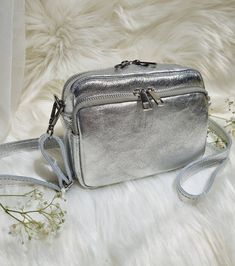 All you want to know about this bag: Two Zipper closures Adjustable crossbody strap  Internal zipped pockets  Interior slip pockets  Silver tone metal hardware  Fully lined interior  Dimensions: 19 cm (L) x 6 cm (W) x 13.5 cm (H). Drop: 31 cm - 62.5 cm Silver Clutch Bags With Silver-tone Hardware, Silver Evening Bag With Zipper Closure, Modern Silver Clutch Bag, Silver Leather Bag With Zipper Closure, Silver Leather Bags With Zipper Closure, Silver Shoulder Bag With Detachable Strap, Metallic Travel Bag With Zipper Closure, Silver Shoulder Bag With Zipper Closure For Evening, Silver Evening Shoulder Bag With Zipper Closure