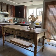 a kitchen with wooden cabinets and an island in front of a stove top oven next to a window