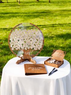 a table topped with a wooden box filled with books and an open book on top of it