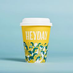 a yellow coffee cup with the words heyday on it's front and bottom