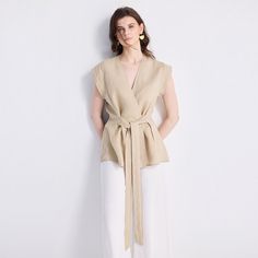 Our Power Moves Top is a wardrobe must-have, your ultimate summer staple! This beautiful wrap top in neutral beige works as well for the office as it does for a dinner with friends. Pair it with sleek trousers or a pair of jeans and see where your day takes you. Elegant V-neck Wrap Top For Work, V-neck Wrap Top With Tie Waist For Work, Summer Khaki V-neck Blouse, Chic Taupe V-neck Top, Spring V-neck Khaki Blouse, Spring Khaki V-neck Blouse, Versatile Beige V-neck Blouse, Feminine Beige Linen Blouse, Elegant Beige Tops For Day Out