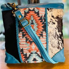 Myra Western Boho Crossbody Cowhide Turquoise Leather Canvas Native American Bag Treat Yourself To This Amazing Bag! Classic Design Brings Together Beautiful Hair-On Hide On The Front And Lovely Woven Canvas On The Back. The Front Also Features Beautiful Upcylced Woven Rug, Framed By Gorgeous Blue Braided Leather. The Interior Features A Zippered Pocket And Zipper Close Top, While There's An Extra Zippered Pocket On The Back. The Matching Detachable Leather Shoulder Strap Is Fully Adjustable. A Multicolor Leather Shoulder Bag With Cell Phone Pocket, Blue Bohemian Satchel For Everyday Use, Multicolor Clutch Bags With Cell Phone Pocket, Leather Shoulder Bag In Turquoise For Everyday Use, Blue Clutch Shoulder Bag For Travel, Bohemian Blue Satchel For Travel, Turquoise Leather Shoulder Bag For Travel, Blue Bohemian Satchel For Travel, Turquoise Bags With Detachable Strap For Daily Use