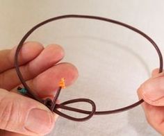 two hands are holding wires in the shape of a circle with an orange star on it