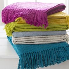 a stack of colorful towels sitting on top of a white counter