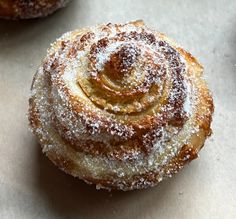 two pastries covered in powdered sugar sit on a table