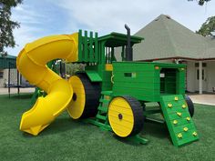 a large green and yellow play set in the grass