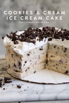 a cake with white frosting and chocolate chips cut in half on a marble surface